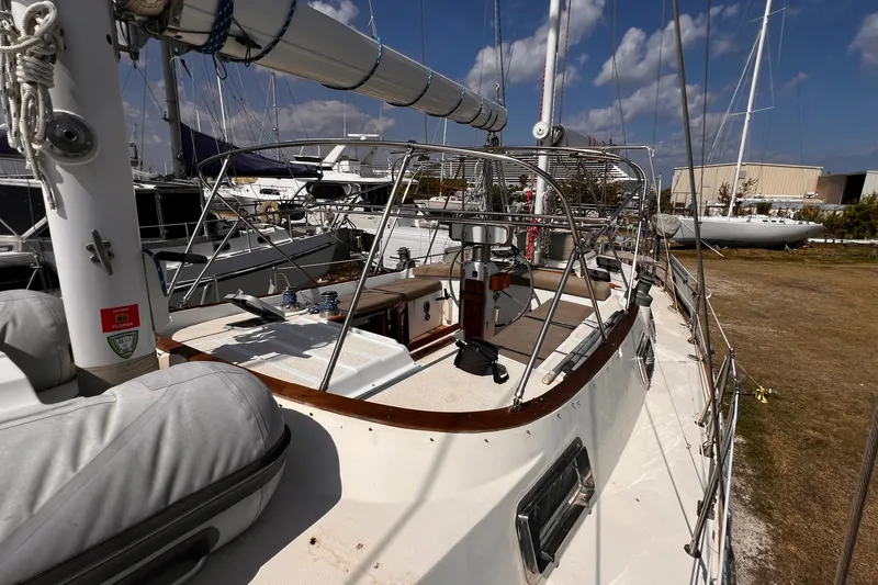 Slide: The Image of 1980 Morgan 462 sailboat docked, showcasing deck and rigging under a clear blue sky. - 2
