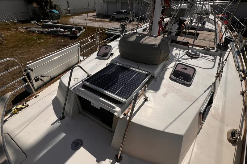 Slide: The Image of 1980 Morgan 462 sailboat deck with solar panel and hatches in a marina setting. - 3