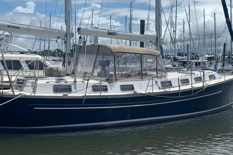 Slide: The Image of 1980 Morgan 462 sailboat docked in a marina, featuring a blue hull and tan canopy. - 30