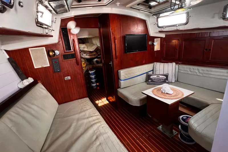 Slide: The Image of Cozy interior of a 1980 Morgan 462 sailboat with wood paneling and seating area. - 5