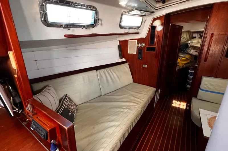 Slide: The Image of Interior of a 1980 Morgan 462 sailboat with wooden paneling and cushioned seating. - 6