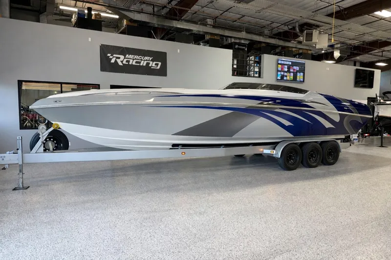 Slide: The Image of 2008 Sleekcraft 34' Heritage boat on trailer in showroom, featuring sleek design and vibrant graphics. - 33