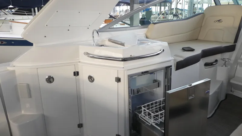 Slide: The Image of Interior of 2019 Monterey 295 Sport Yacht with fridge and seating area. - 16