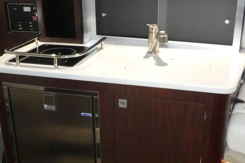 Slide: The Image of Monterey 295 Sport Yacht 2019 kitchenette with stove and sink. - 33
