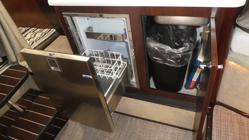 Slide: The Image of Monterey 295 Sport Yacht 2019 kitchen area with dishwasher and trash bin. - 34