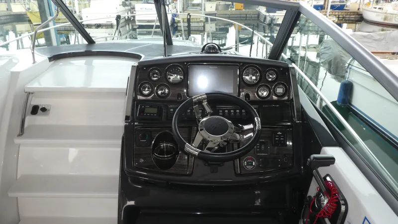 Slide: The Image of 2019 Monterey 295 Sport Yacht cockpit with steering wheel and instruments. - 9
