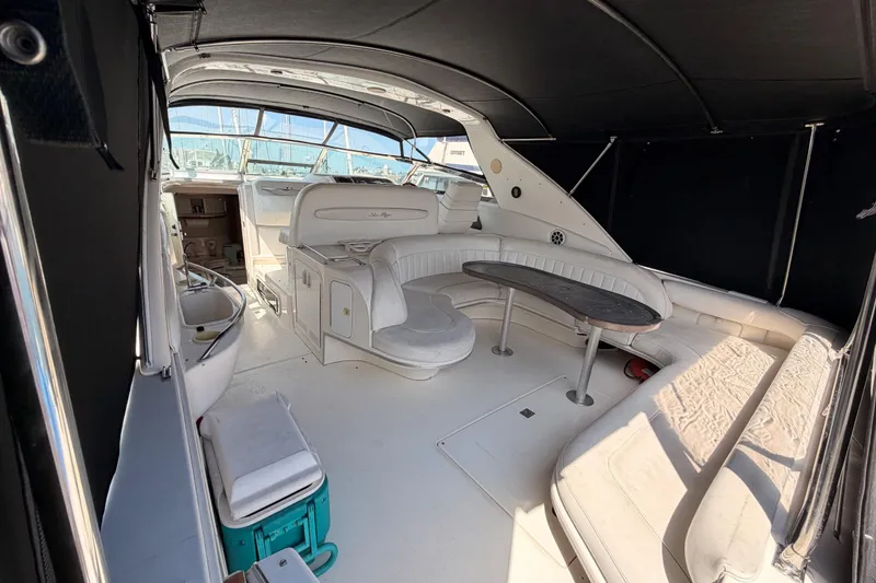 Slide: The Image of Interior view of a 1996 Sea Ray 450 Sundancer yacht with white seating and a wooden table. - 10