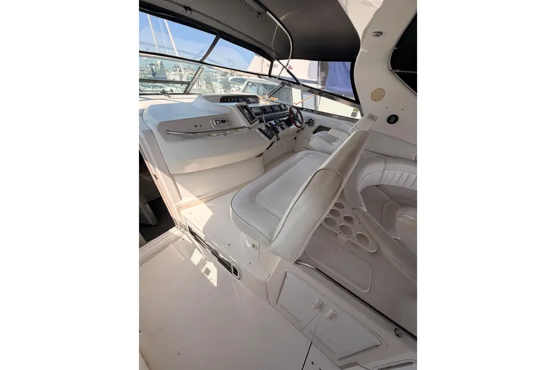 Slide: The Image of 1996 Sea Ray 450 Sundancer cockpit with white seating and control panel. - 13
