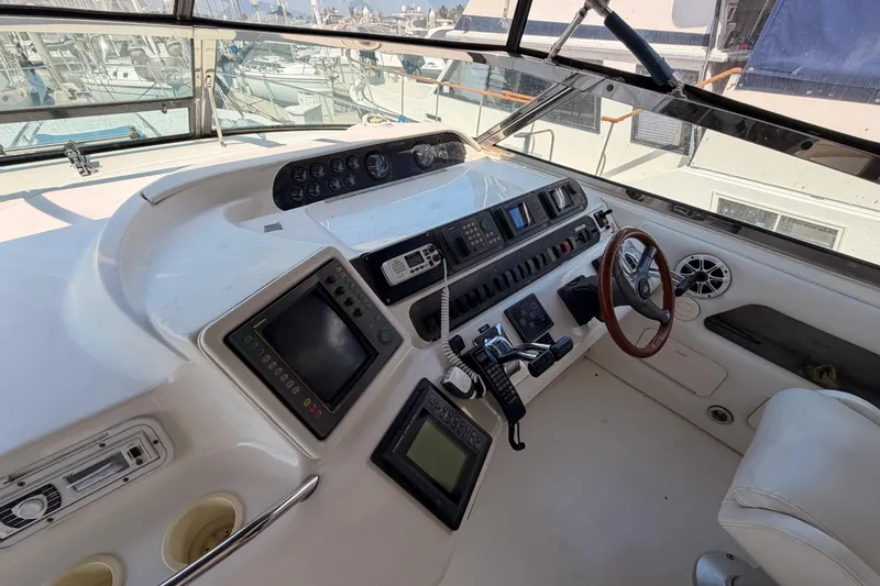 Slide: The Image of Cockpit of 1996 Sea Ray 450 Sundancer with steering wheel and navigation controls. - 14