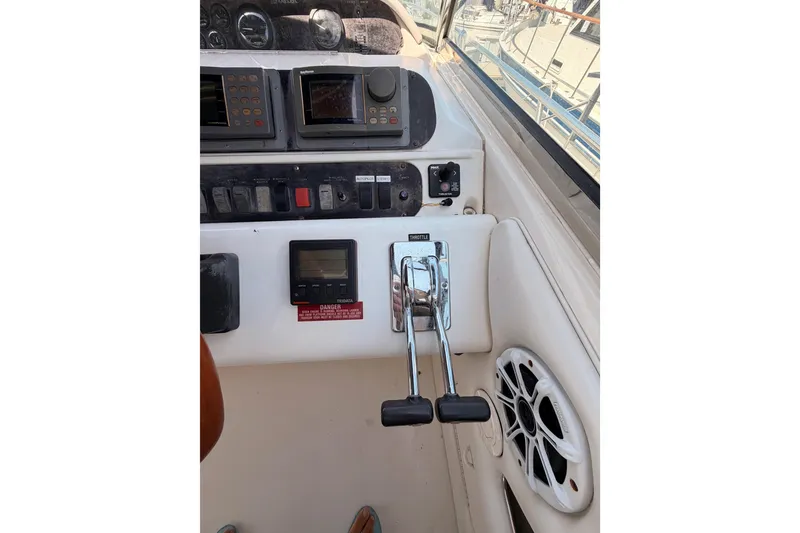 Slide: The Image of 1996 Sea Ray 450 Sundancer helm with controls and gauges, featuring dual throttle levers. - 18