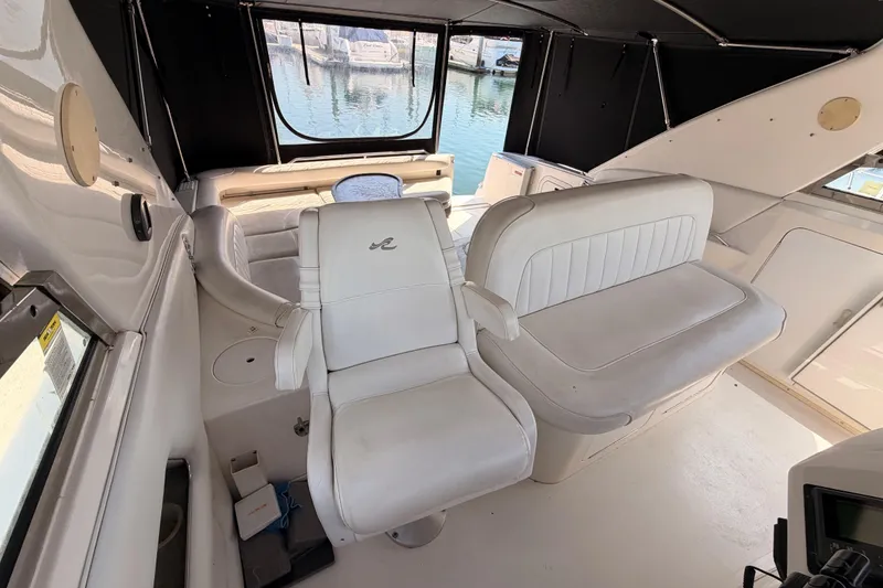 Slide: The Image of 1996 Sea Ray 450 Sundancer cockpit with white seating and marina view. - 22