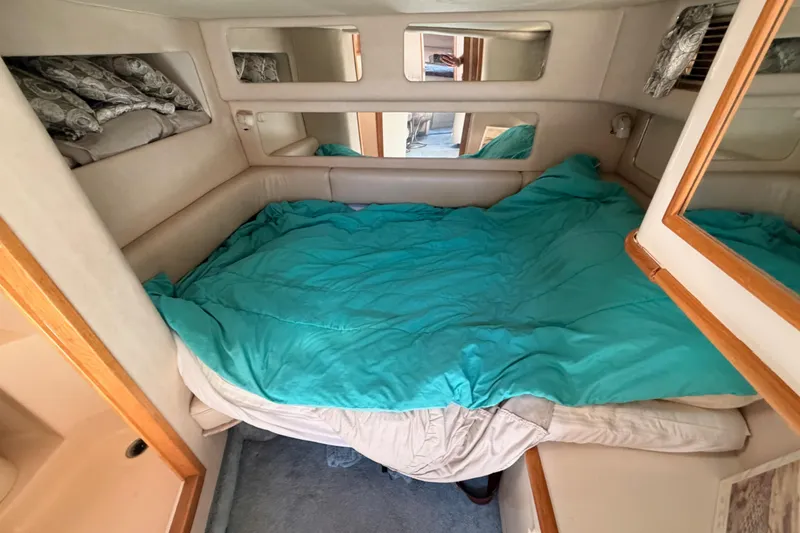 Slide: The Image of Cozy cabin interior of 1996 Sea Ray 450 Sundancer with teal bedding. - 34
