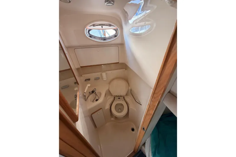 Slide: The Image of Bathroom interior of 1996 Sea Ray 450 Sundancer yacht, featuring compact design and porthole window. - 35