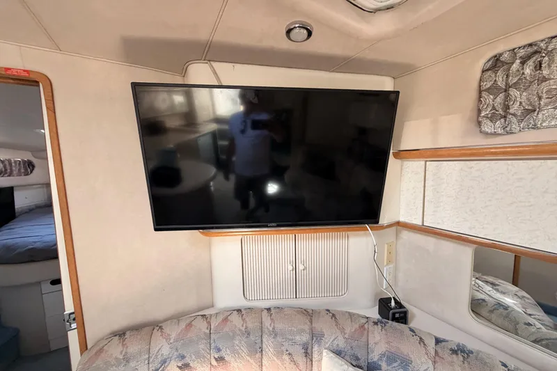 Slide: The Image of Interior of 1996 Sea Ray 450 Sundancer with mounted TV and cozy seating area. - 38