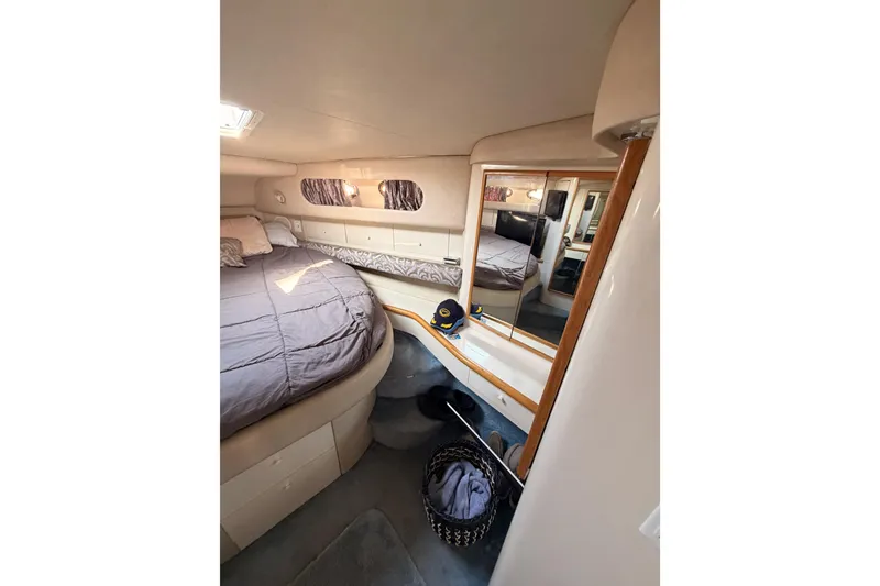Slide: The Image of 1996 Sea Ray 450 Sundancer cabin interior with bed, mirror, and storage. - 43