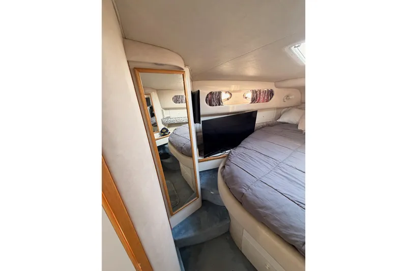 Slide: The Image of Interior cabin of 1996 Sea Ray 450 Sundancer with bed, mirror, and TV. - 44