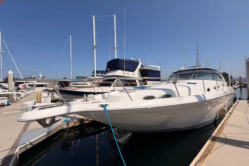 Slide: The Image of 1996 Sea Ray 450 Sundancer yacht docked at marina under clear blue sky. - 5