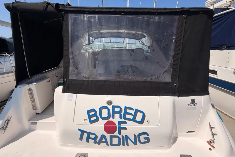 Slide: The Image of 1996 Sea Ray 450 Sundancer yacht with "Bored of Trading" text on the stern. - 8