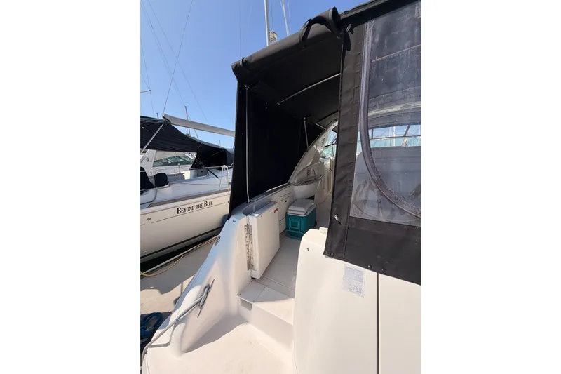 Slide: The Image of 1996 Sea Ray 450 Sundancer yacht with black canopy docked at marina. - 9