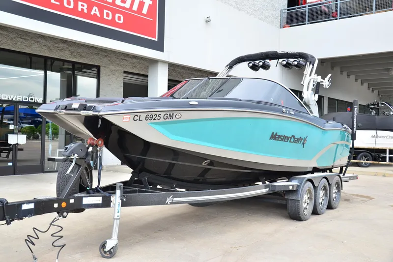 Slide: The Image of 2017 MasterCraft X26 boat on trailer outside showroom, featuring sleek design and vibrant color. - 6
