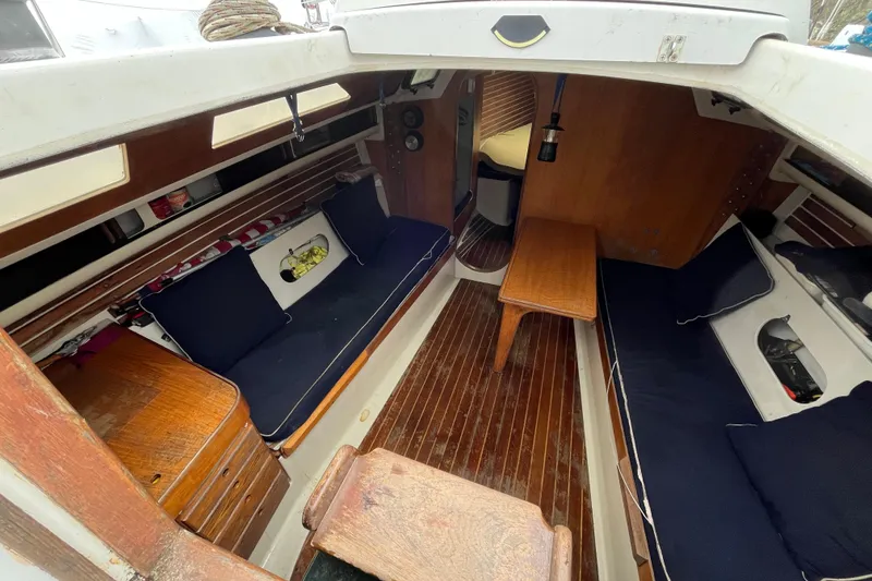 Slide: The Image of Interior of 1986 Alsberg Brothers Express 37 sailboat with wooden furnishings and navy cushions. - 13