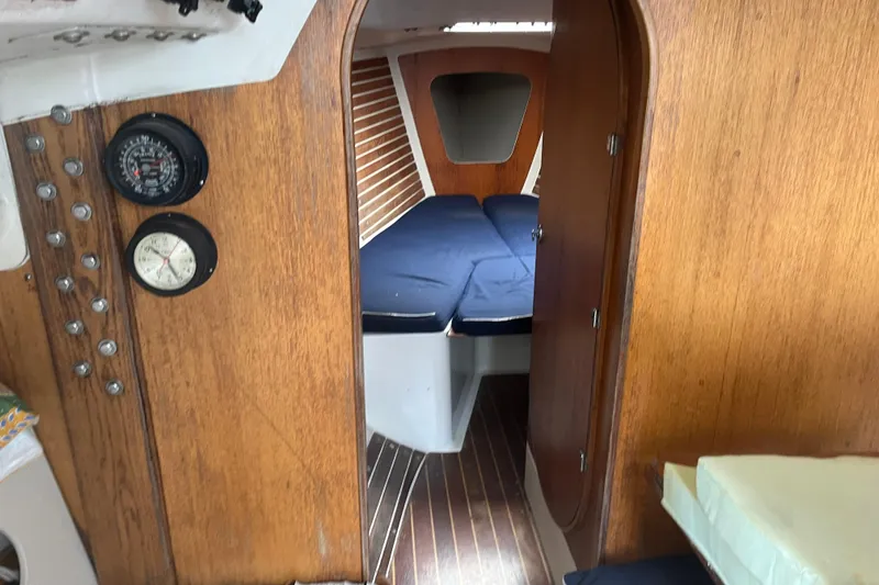 Slide: The Image of Interior of 1986 Alsberg Brothers Express 37 sailboat with wooden paneling and cozy sleeping area. - 17