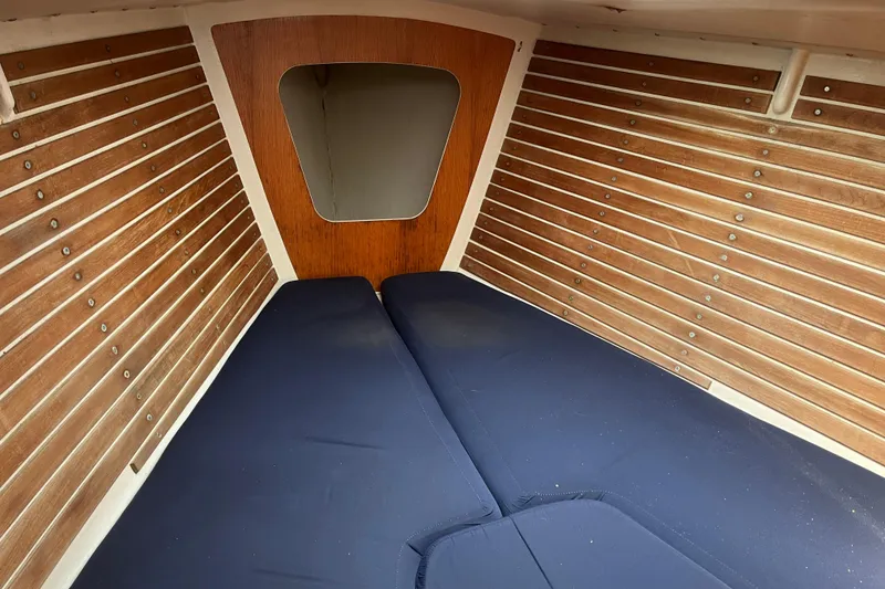Slide: The Image of Interior cabin of 1986 Alsberg Brothers Express 37 sailboat with wooden paneling and blue cushions. - 18