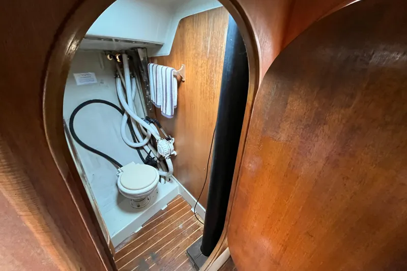 Slide: The Image of Interior of 1986 Alsberg Brothers Express 37 sailboat, featuring compact wooden bathroom. - 19
