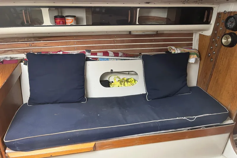 Slide: The Image of Interior of 1986 Alsberg Brothers Express 37 sailboat with navy cushions and wooden accents. - 20
