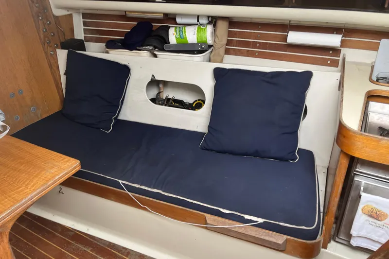Slide: The Image of Interior of 1986 Alsberg Brothers Express 37 sailboat with navy cushions and wooden accents. - 21