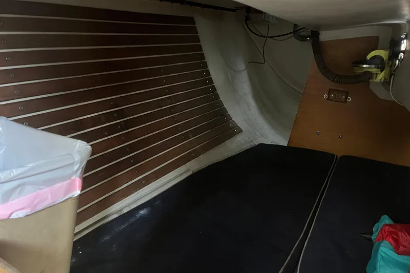 Slide: The Image of Interior of 1986 Alsberg Brothers Express 37 sailboat, featuring wooden paneling and storage area. - 27
