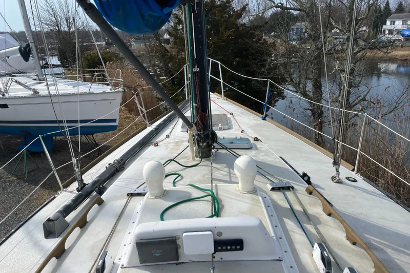 Slide: The Image of 1986 Alsberg Brothers Express 37 sailboat deck with rigging and equipment, docked near water. - 7