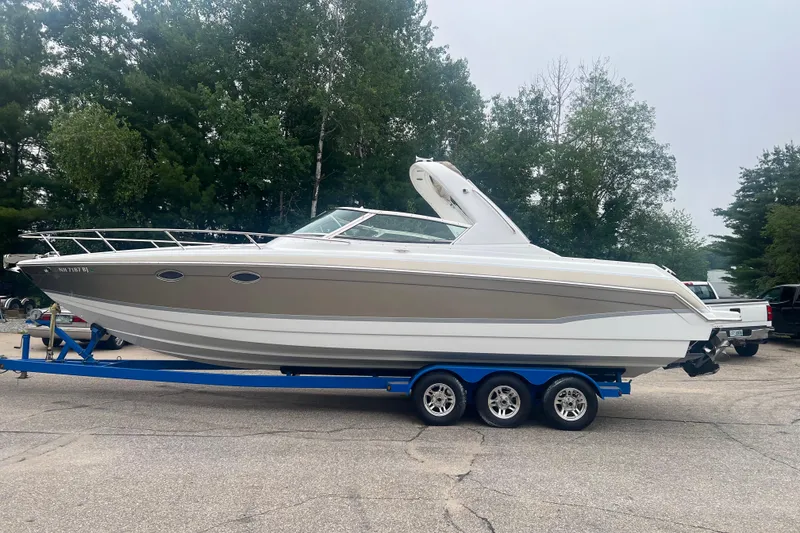 Slide: The Image of 2007 Formula 330 Sun Sport boat on trailer, parked outdoors with trees in background. - 2