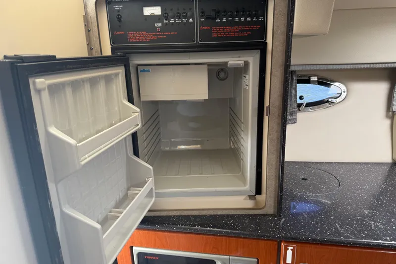 Slide: The Image of 2007 Formula 330 Sun Sport interior with open mini fridge and control panel. - 9