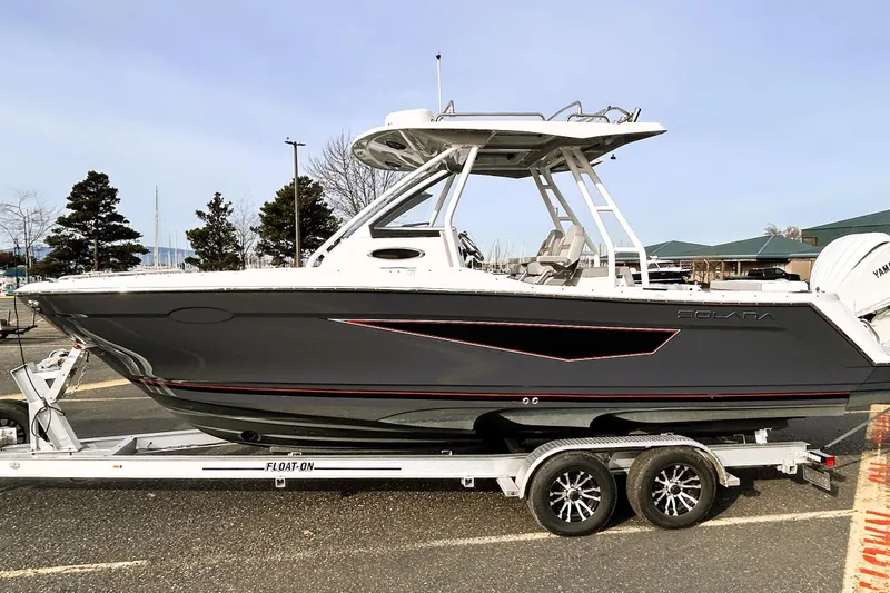 Slide: The Image of 2025 Solara S-250 CW boat on trailer, sleek design, parked outdoors. - 12