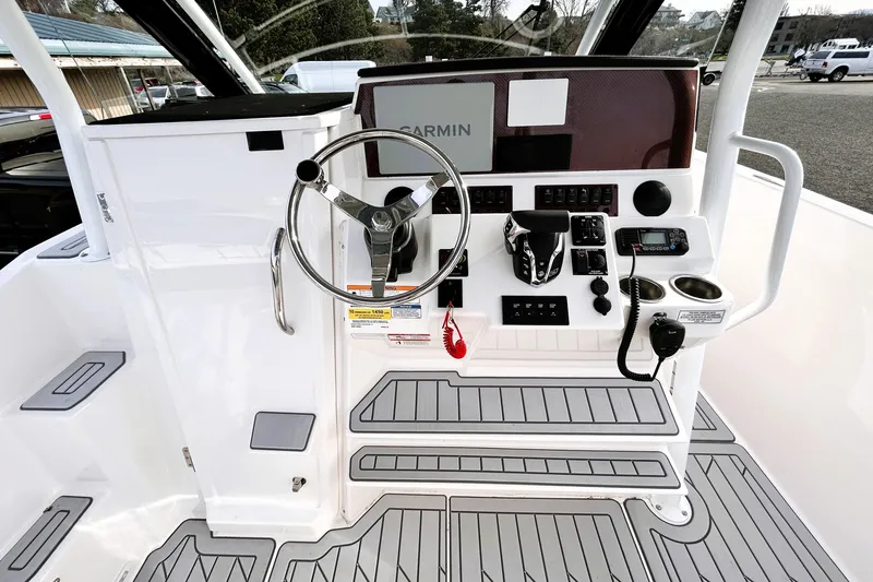 Slide: The Image of 2025 Solara S-250 CW boat cockpit with steering wheel, controls, and Garmin navigation system. - 18