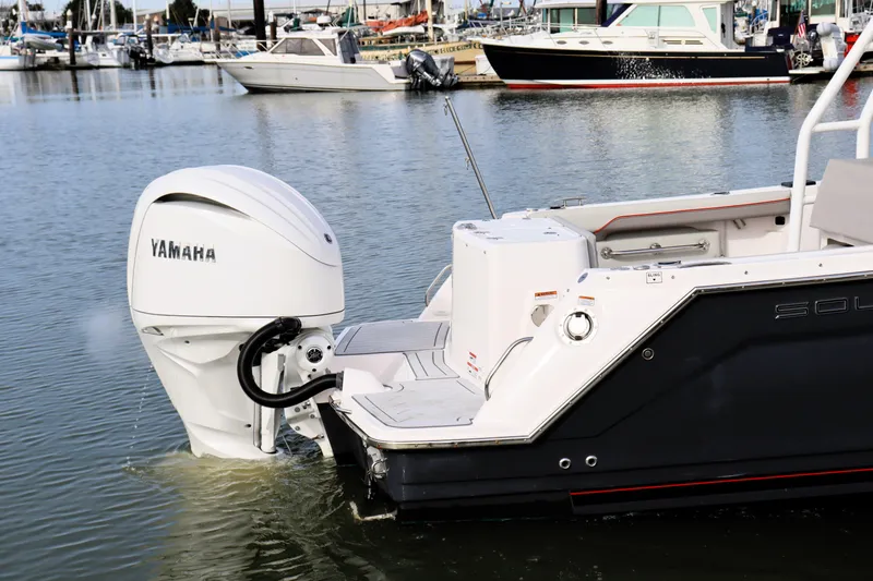 Slide: The Image of 2025 Solara S-250 CW boat with Yamaha outboard motor in marina setting. - 2