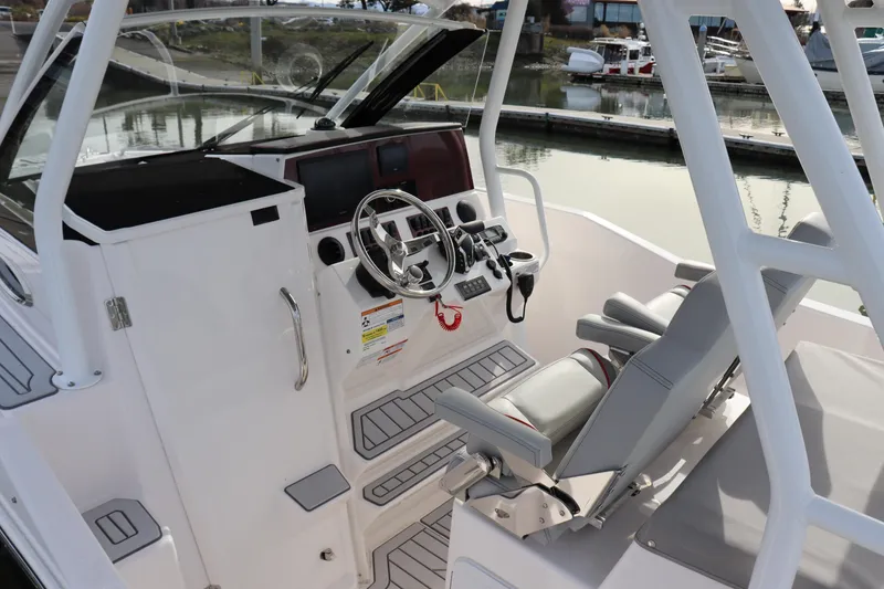 Slide: The Image of 2025 Solara S-250 CW boat cockpit with modern steering and seating at marina. - 20