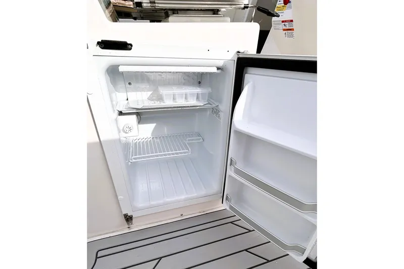 Slide: The Image of Open refrigerator on Solara S-250 CW boat, showcasing interior shelves and storage compartments. - 32