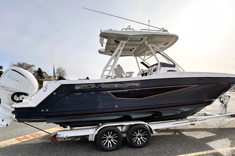 Slide: The Image of 2025 Solara S-250 CW boat on trailer with Yamaha engine, parked outdoors. - 6