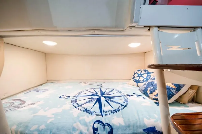 Slide: The Image of 2006 Hydra-Sports Vector 3300 VX cabin with nautical-themed bedding and cozy lighting. - 10