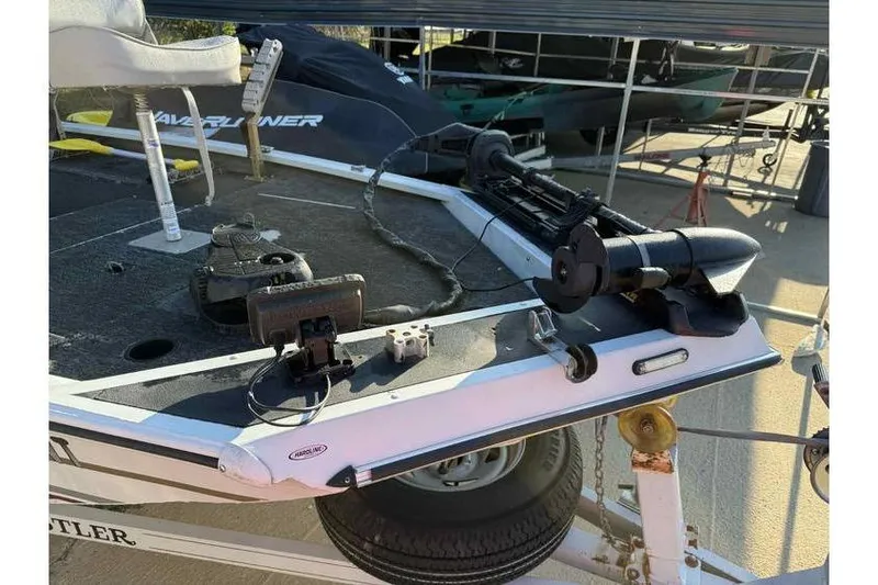 Slide: The Image of 1997 Alumacraft Super Bandit boat deck with fishing equipment and motor. - 6