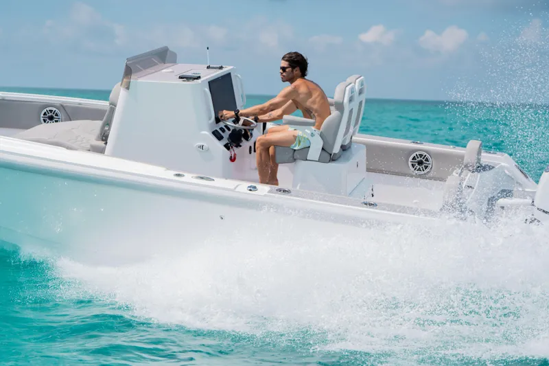 Slide: The Image of Man driving Dynamic D-250DF boat on turquoise ocean, 2026 model. - 2