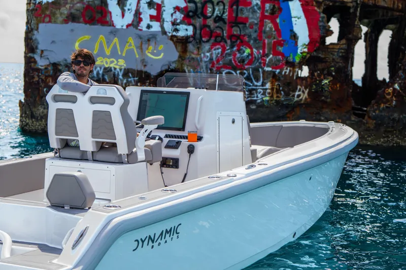 Slide: The Image of A person on a Dynamic D-250DF boat near a graffiti-covered structure, 2026 model. - 5