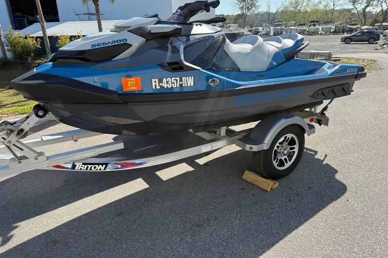 The Image of 2019 Sea Doo GTX jet ski on Triton trailer, parked outdoors. - 1