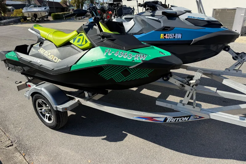 Slide: The Image of 2019 Sea Doo GTX jet ski on trailer, green and black design, parked outdoors. - 3