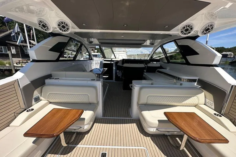 Slide: The Image of 2024 Cruisers Yachts 50 GLS interior with luxurious seating and wooden tables. - 11