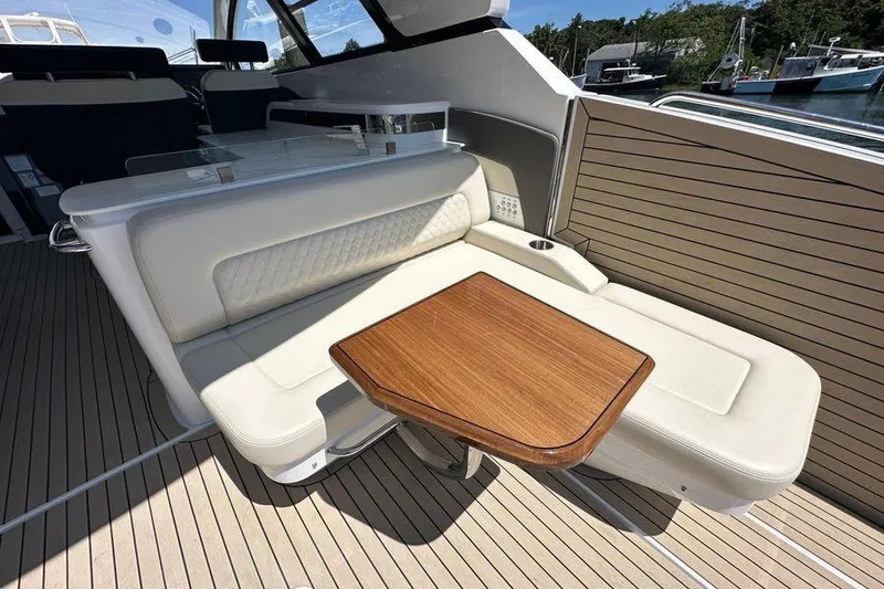 Slide: The Image of Luxurious seating area on 2024 Cruisers Yachts 50 GLS with elegant wood table. - 13