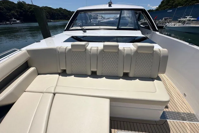 Slide: The Image of 2024 Cruisers Yachts 50 GLS with luxurious seating on deck, docked by the water. - 20