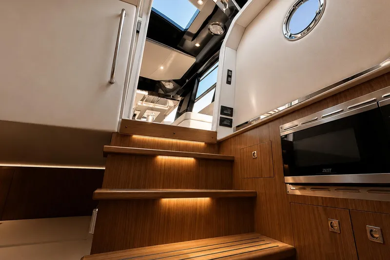 Slide: The Image of Interior view of 2024 Cruisers Yachts 50 GLS, featuring elegant wooden stairs and modern design. - 28